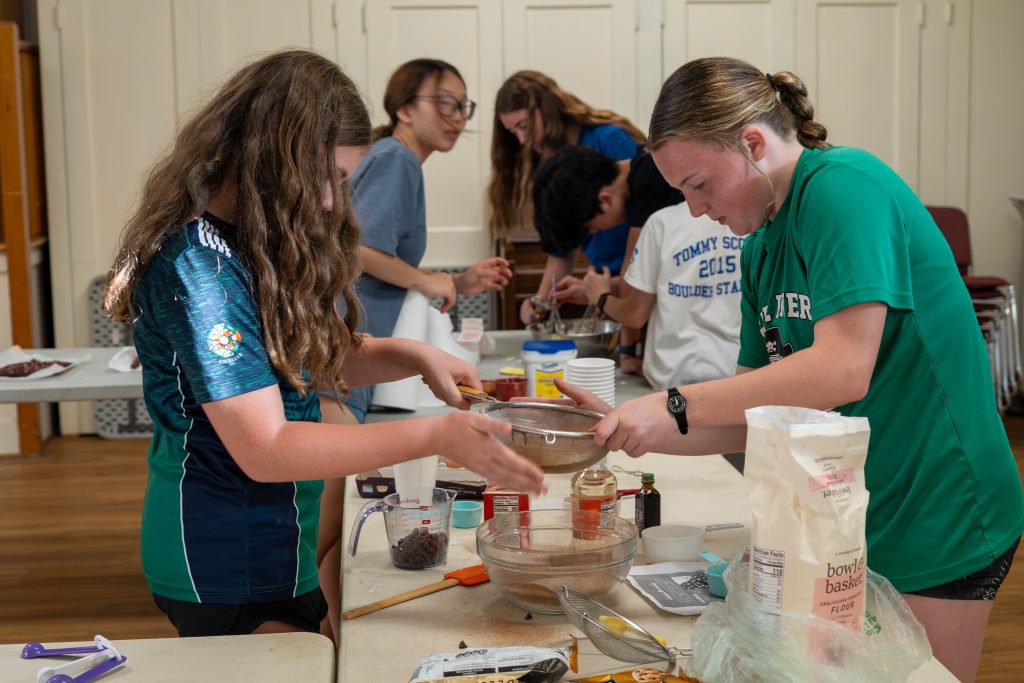 Teens preparing ingredients for baking brownies in a kitchen setting