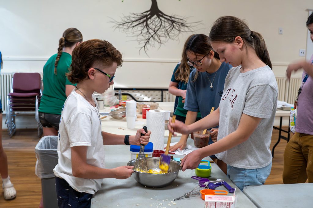 Children mixing ingredients in a kitchen for baking brownies